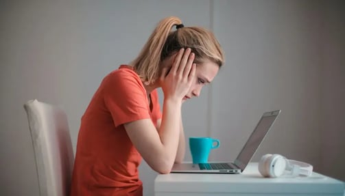 Young troubled woman using laptop at home