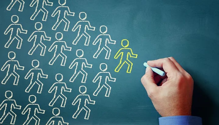 Chalk and board illustration of group of people following a leader. (1)