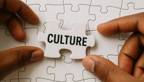 A person assembling a puzzle piece labeled "culture," symbolizing the importance of cultural understanding