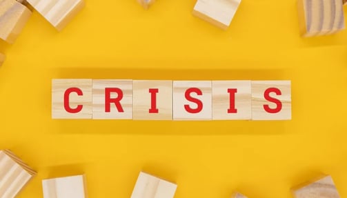 The word crisis written on wooden blocks in red with yellow background 